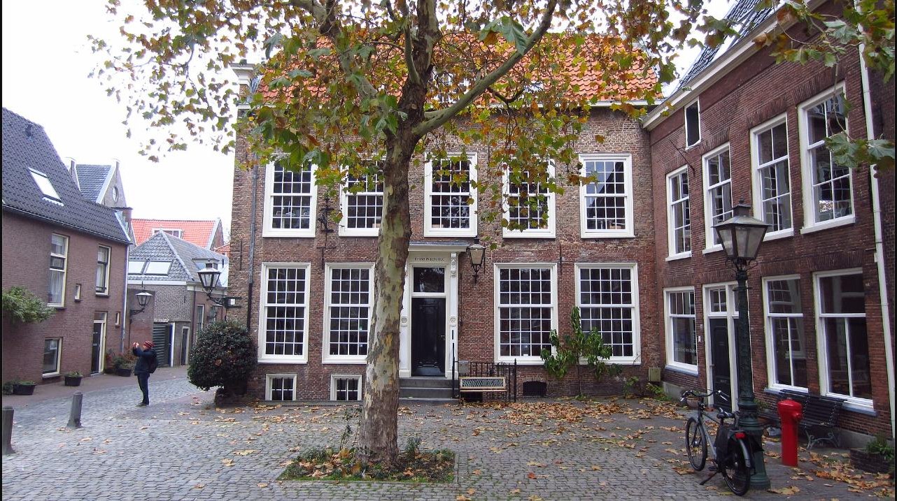 The Pieterskerkhof square in Leiden today, with the churchyard buildings and a large tree